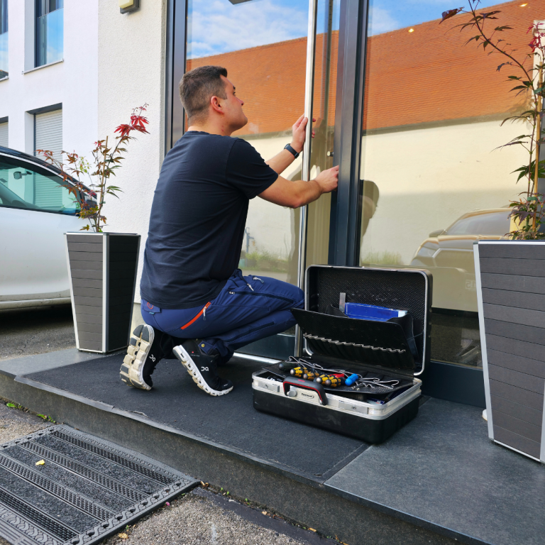 Schlüsseldienst Schlüssel Schalk bei der Türöffnung Schlüssel Schalk Schlüsselnotdienst öffnet eine Hauseingangstüre und bei sich hat er einen Werkzeugkasten